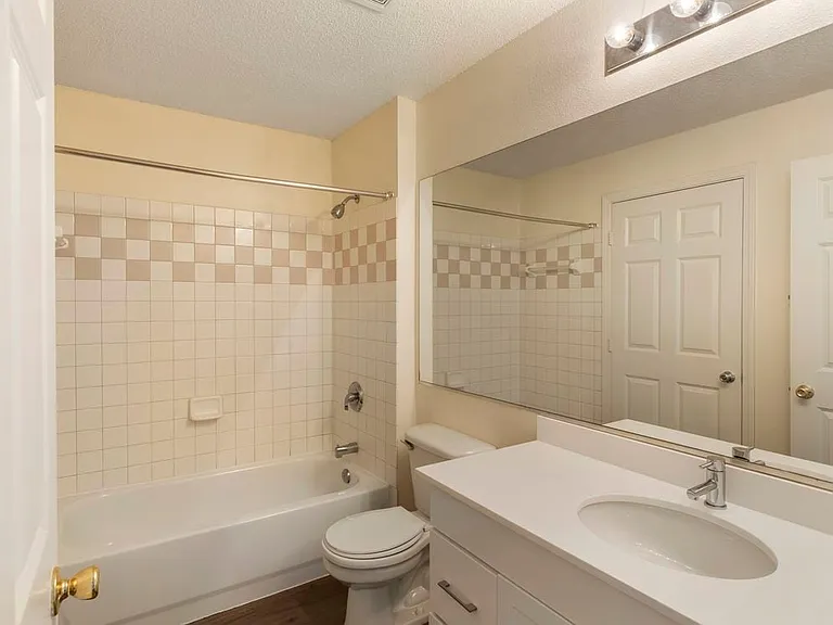 Renovated Package I bath with white granite countertops, white cabinetry, and hard surface plank flooring