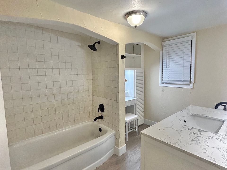 Well lit bathroom including backlit mirror, powder deskset, vanity with tons of storage and new bath fixtures
