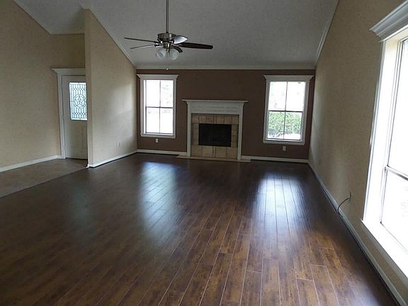 Living/Dining with wood flooring, beautiful fireplace and high ceilings.