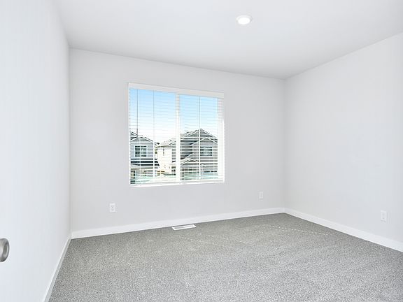 The master bedroom is spacious with a large window.