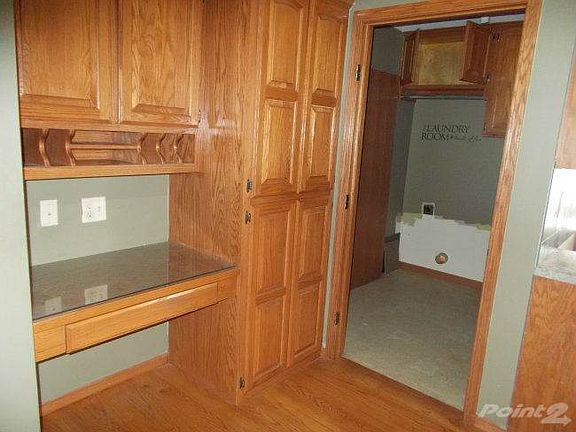 Built in desk and cubbies in kitchen, laundry room with storage in own area