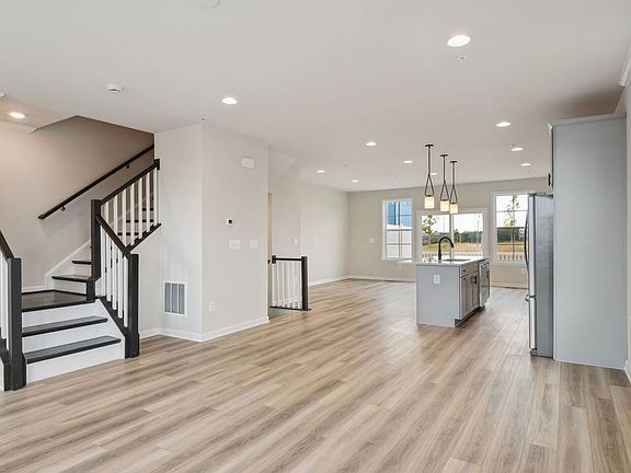 Living room with LVP floors and open kitchen in a DRB Homes Davenport Plan at the Laurel Overlook co