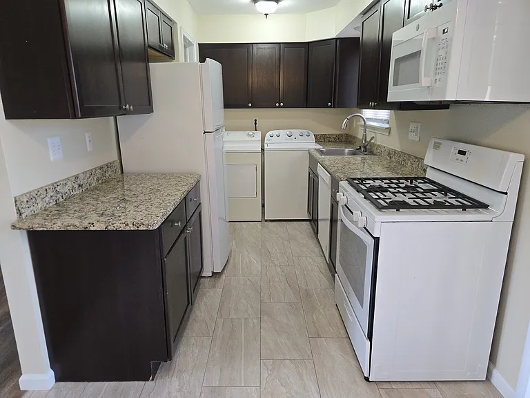 Kitchen with over the range microwave and gas stove (gas included in rent at no charge).