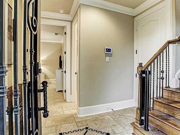 The first floor contains two guest rooms and a full bathroom. The door by the stairs leads to the garage.