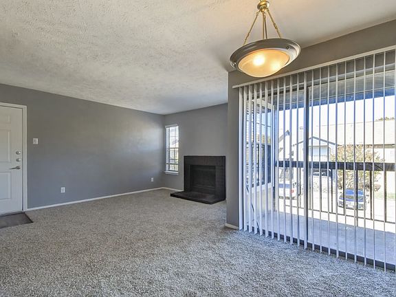 Spacious living area with plush carpeting, designer lighting, and large windows that fill your home with natural light.