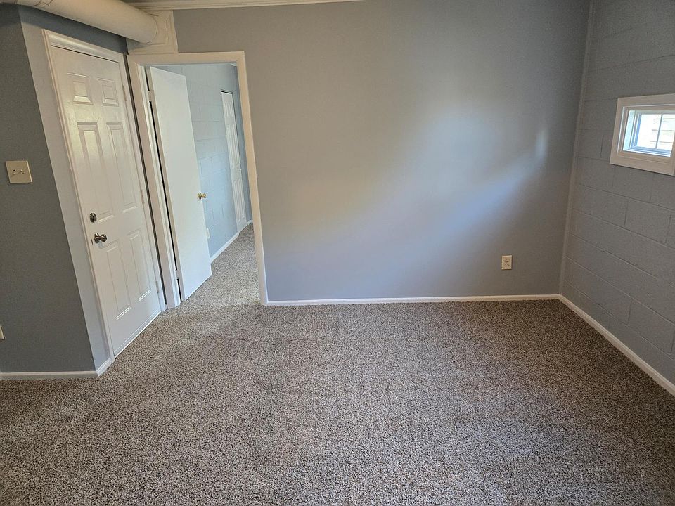 Front door facing into living room and the entrance to bedroom.