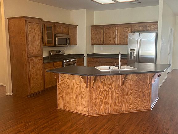 Kitchen with stainless steel appliances, including refrigerator