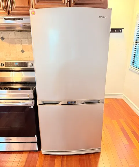 Existing Samsung refrigerator. Refrigerator on top and freezer with icemaker on the bottom.