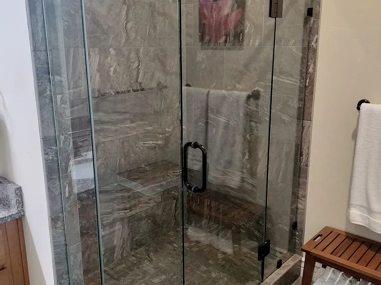 Spacious master bathroom with double sinks, a glass shower, and a large deep tub_perfect for relaxing after a long day. Designed for comfort and style, this serene retreat offers the ultimate in convenience and luxury.
