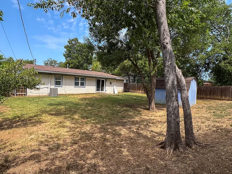Another look at the generous backyard, with mature trees providing shade and plenty of open outdoor space.