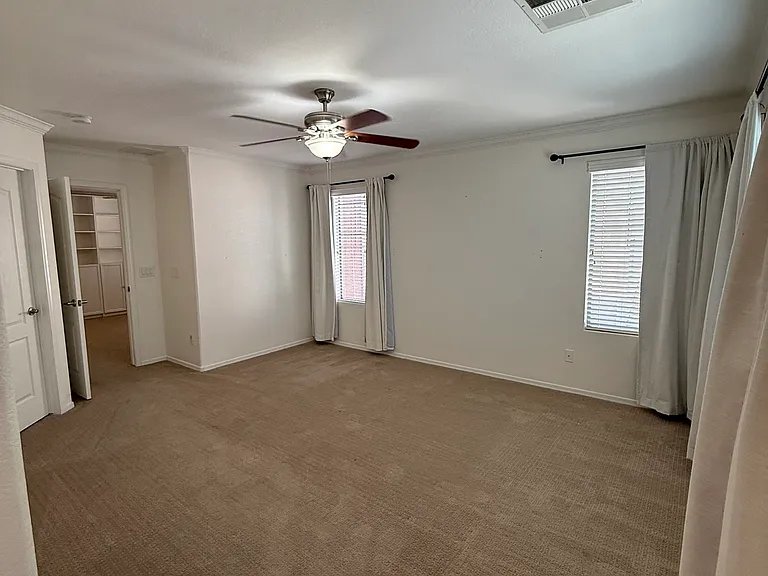 Spacious primary retreat featuring custom designer wall treatments and abundant natural light.