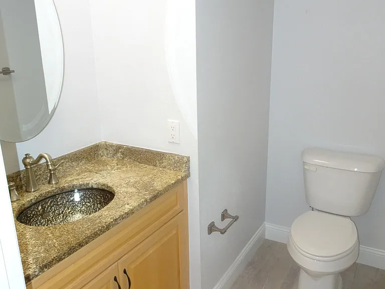 This 1/2 bath off the living area has a beautiful glass sink and attractive sparkling granite.