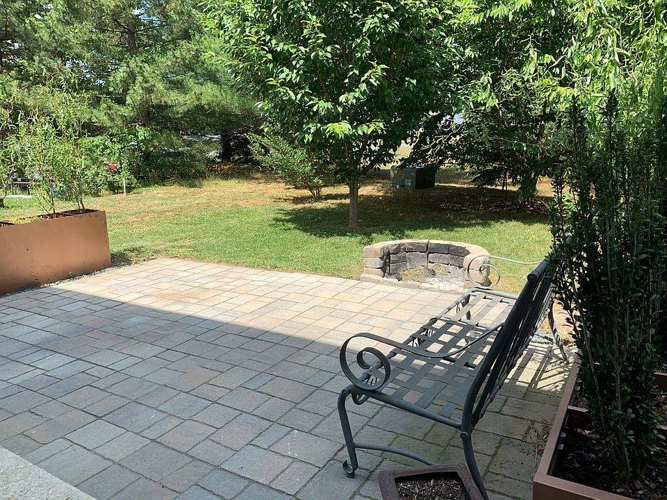 Great outdoor patio with fire pit and planters. Wonderful trees.