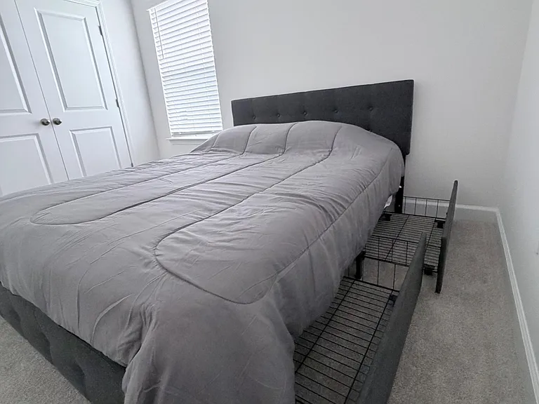 Private bedroom with a full bed, carpeted floors, and a closet, plus a window with blinds for natural light and privacy.