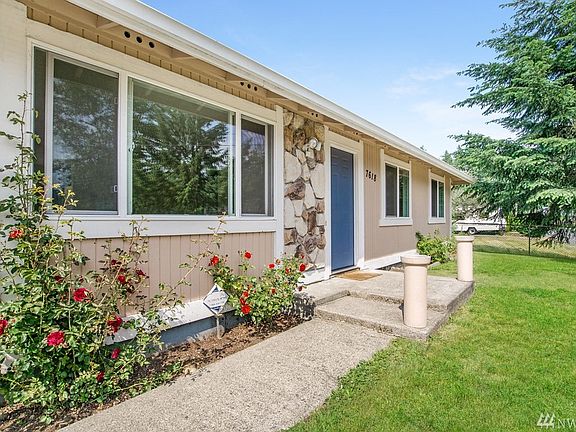 Entrance has rock trim and updated windows over time.
