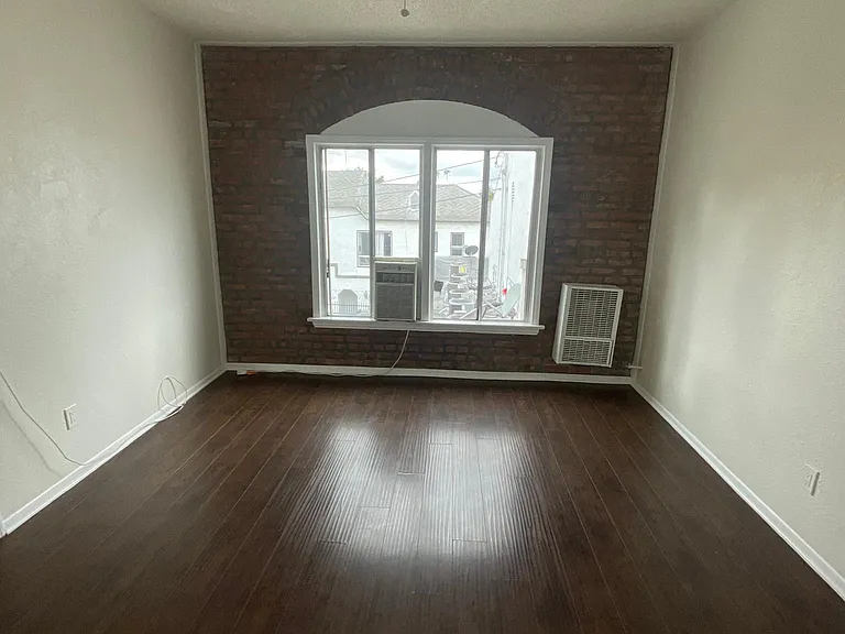 Bedroom with hardwood floor, ceiling fan, and air conditioning/heat at Sanborn/Hoover Apartments in Los Angeles, CA.
