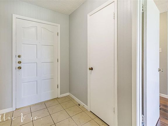 Entrance has a beautiful wood door with ceramic tile. Closed door is to a coat closet.