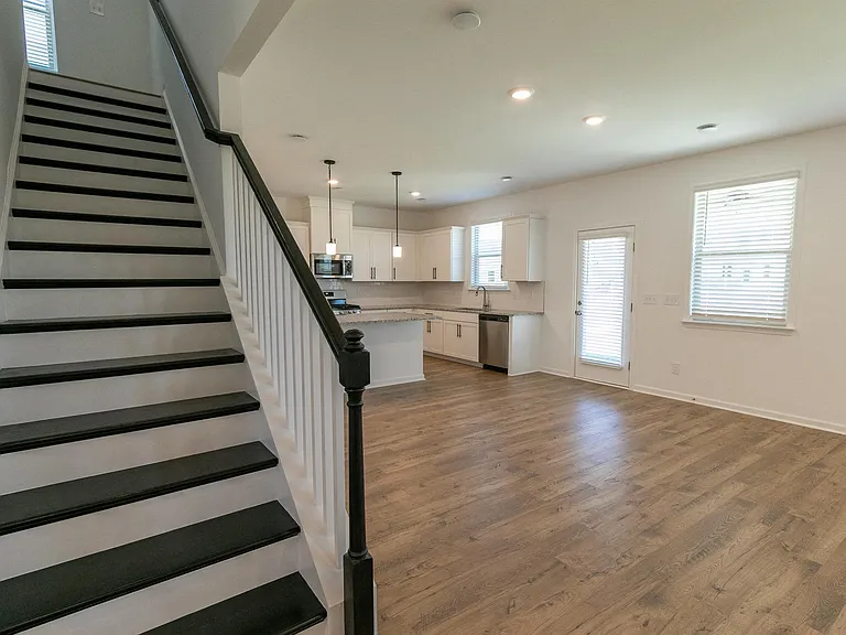 Spacious living room featuring wood floors, a ceiling fan, and plenty of room to relax.