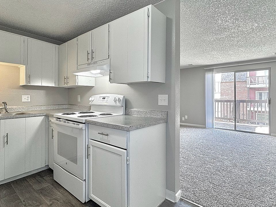 Kitchen/ dining area connects to large living room with sunlit patio.