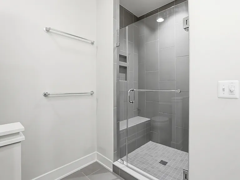 Primary bathroom floor to ceiling tiled standing shower.
