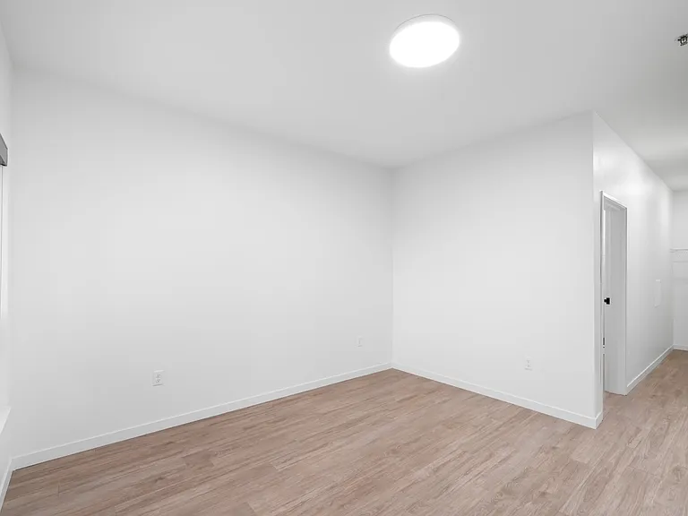 Bright, spacious room with sleek hardwood flooring, modern lighting, and a built-in closet. Bright, spacious room with sleek hardwood flooring, modern lighting, and a built-in closet.