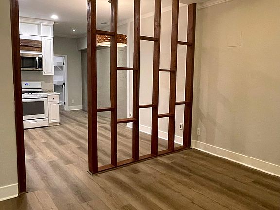 Open-concept living room, looking into the kitchen. High ceiling!