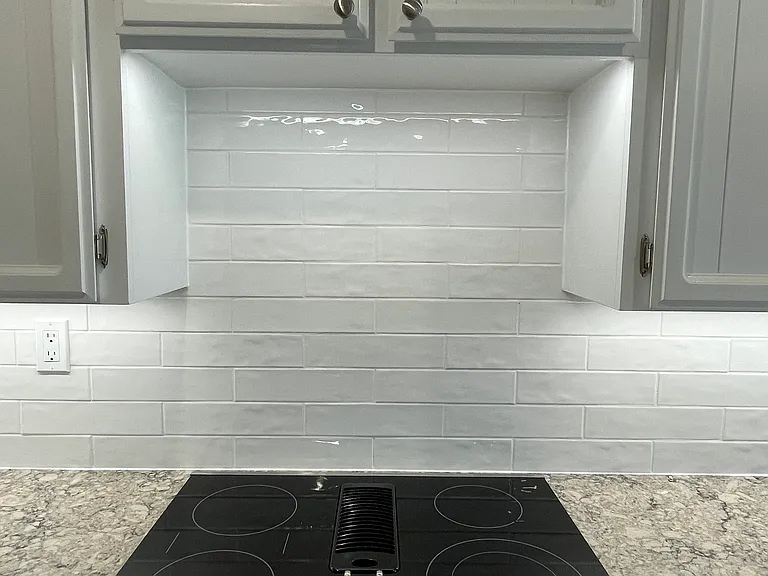 New cooktop with downward draft ventilation and brand new backsplash.