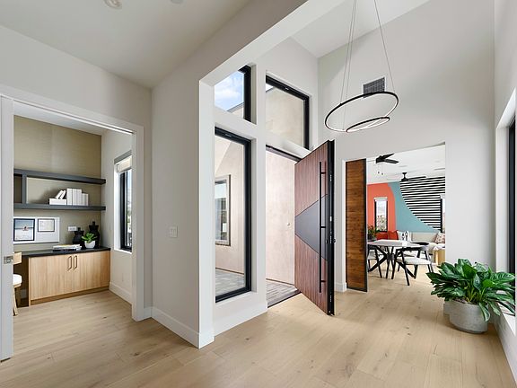 A modern and minimalist hallway with white walls, wooden floors, and various decorative elements suc