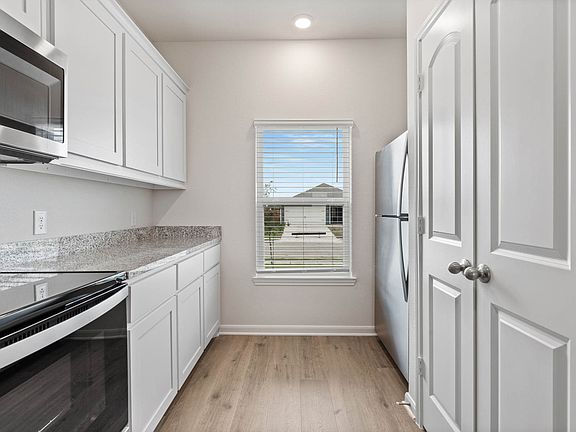 The kitchen of the Driftwood has beautiful white wood cabinets.