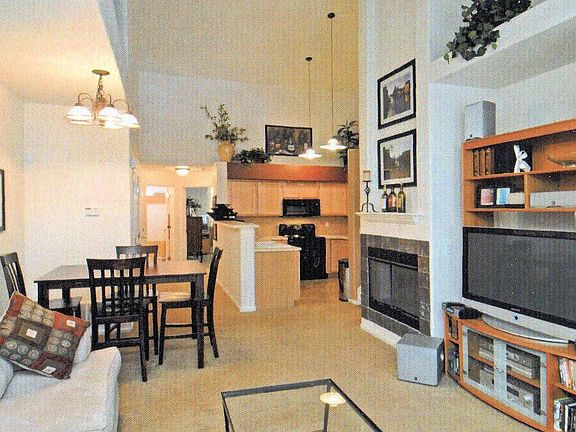 Living room view showing kitchen and gas fireplace