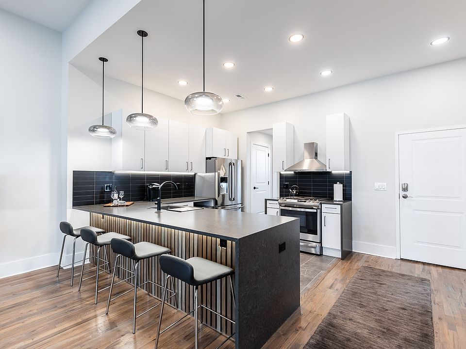 Kitchen peninsula with wood slat detail and underlit.