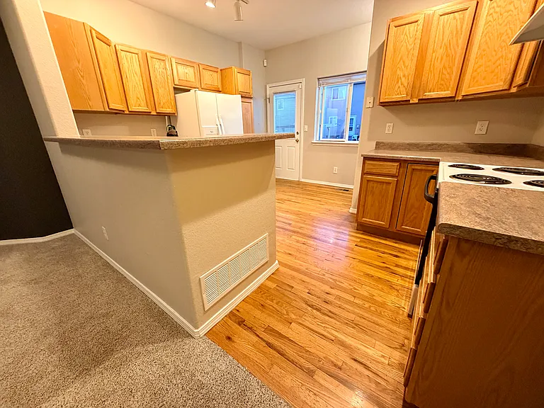 Additional perspective showing cabinetry, appliances, and connection to living space from the main level bathroom view.
