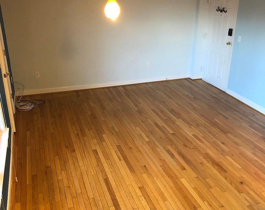 Living room. Looking south from edge of kitchen. Front door to right, windows and bedroom to left.