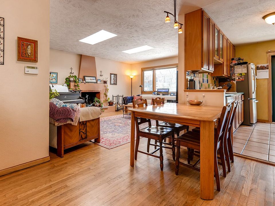 Open living & dining area with skylights, hardwood floors, french doors, cherry cabinets and mexican tile