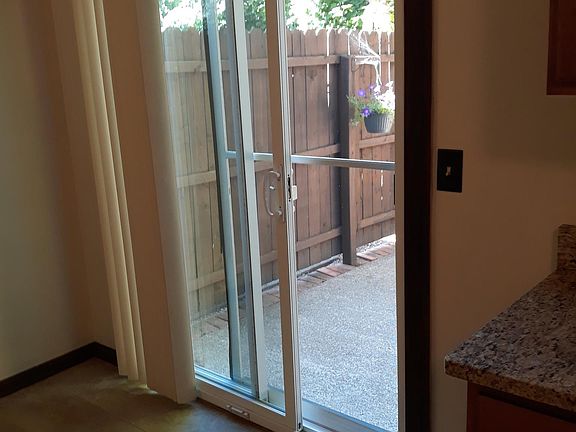 sliders off kitchen lead to a small privacy fenced patio