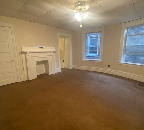 Large living room with decorative fireplace and large windows