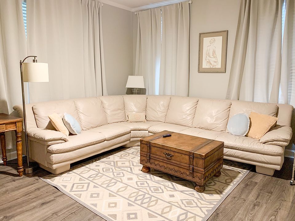 The living room features a large l-shaped sectional and a smart TV.