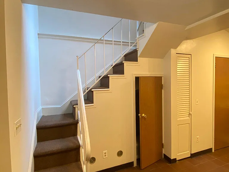 STAIRS TO LOWER LEVEL. KITCHEN TO RIGHT, STORGEAGE CLOSET UNDER STAIRS