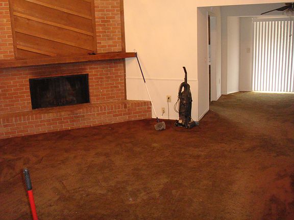 Den has a large woodburning fireplace.