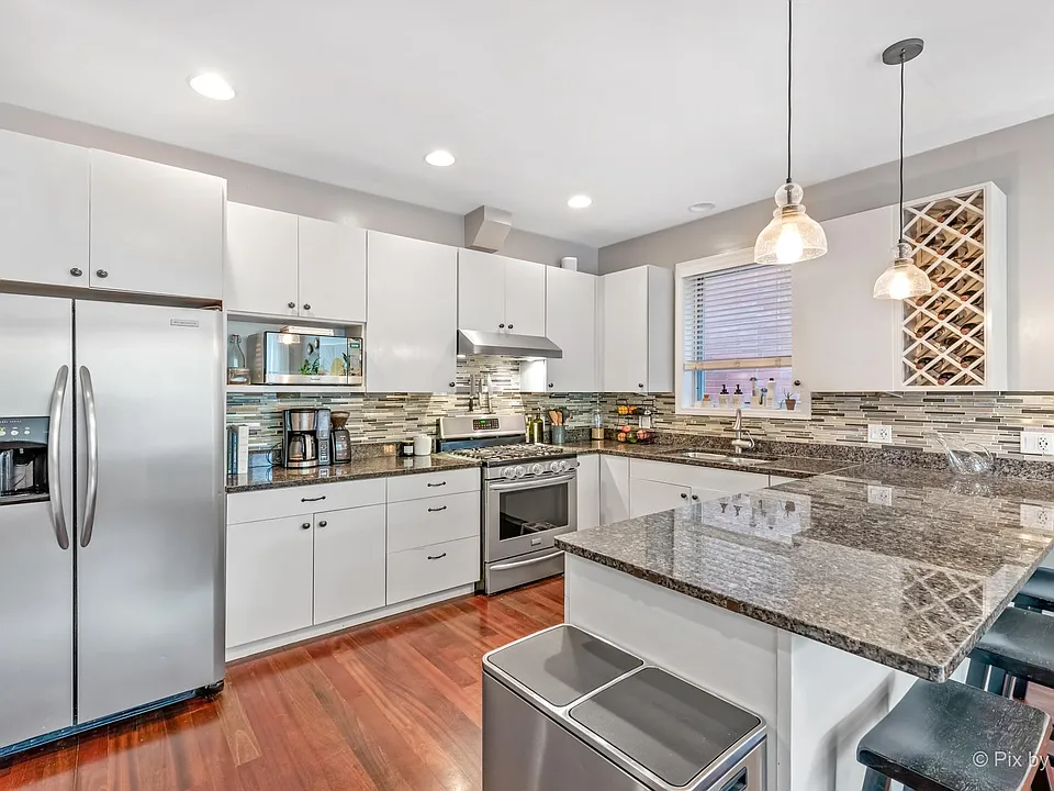 Kitchen, with garbage disposal, dishwasher, and vent hood.