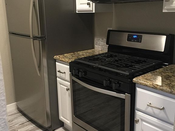 Kitchen with newer cabinets, stove, microwave and refrigerator