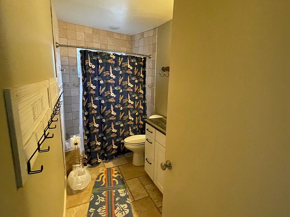 Bathroom with a tub off hall next to bunkbed room