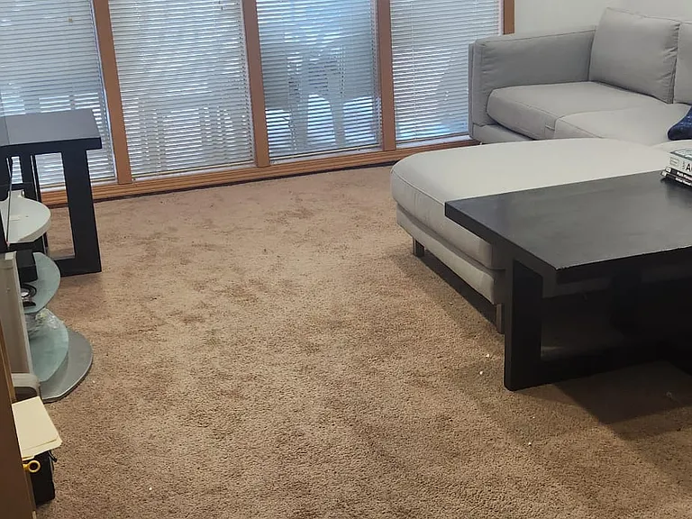 Apartment livingroom with view of floor to ceiling windows and recessed lighting