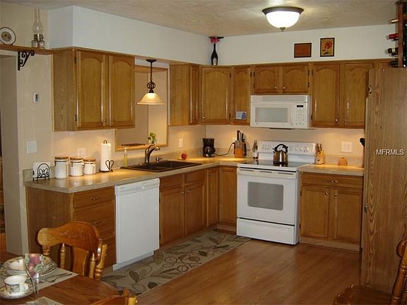 Kitchen with newer countertops, dishwasher, sink and under cabinet lighting.