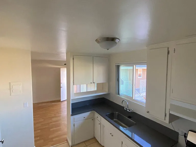 Kitchen with gas range and spacious white cabinets at Edison Apartments in Burbank, California.