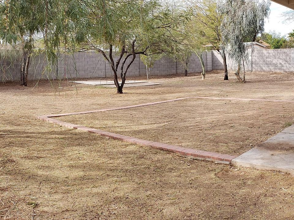 Backyard has grass area with automatic sprinklers