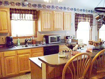 Another view of those bright and rich Hickory cabinets and all the natural light from oversized windows. Is this not an inviting place to gather?