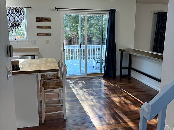 Entry into kitchen and living area. Sliding door opens to outdoor deck and beautiful trees in backyard