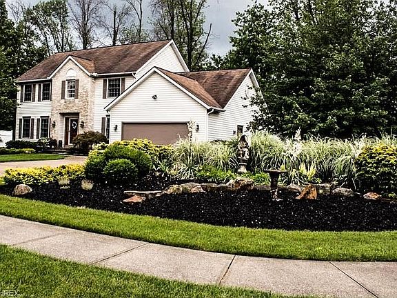 Gorgeous landscaping outlines the double driveways on this half acre lot.  New garage door installed in 2015.
