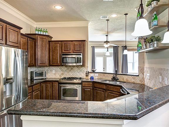 Kitchen includes: French door refrigerator equipped with filtered water dispenser, large freezer, and double ice machine; 4-burner gas stove and oven; microwave; wine fridge; dishwasher; large pantry; plenty of cabinetry; 2 breakfast bars that open to din